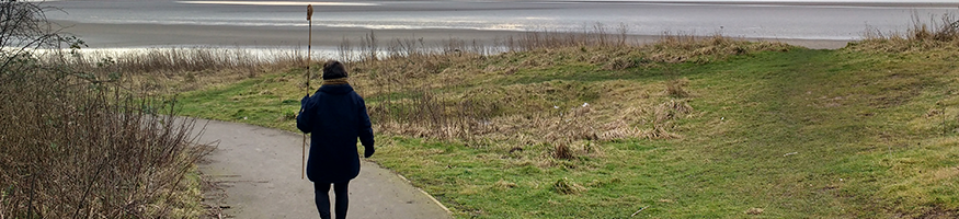 woman walking in dunes on a grey day